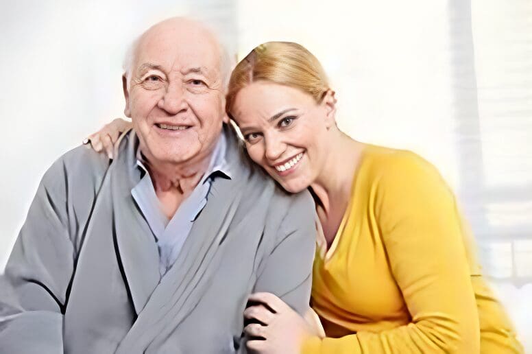 Smiling woman hugging elderly man indoors.